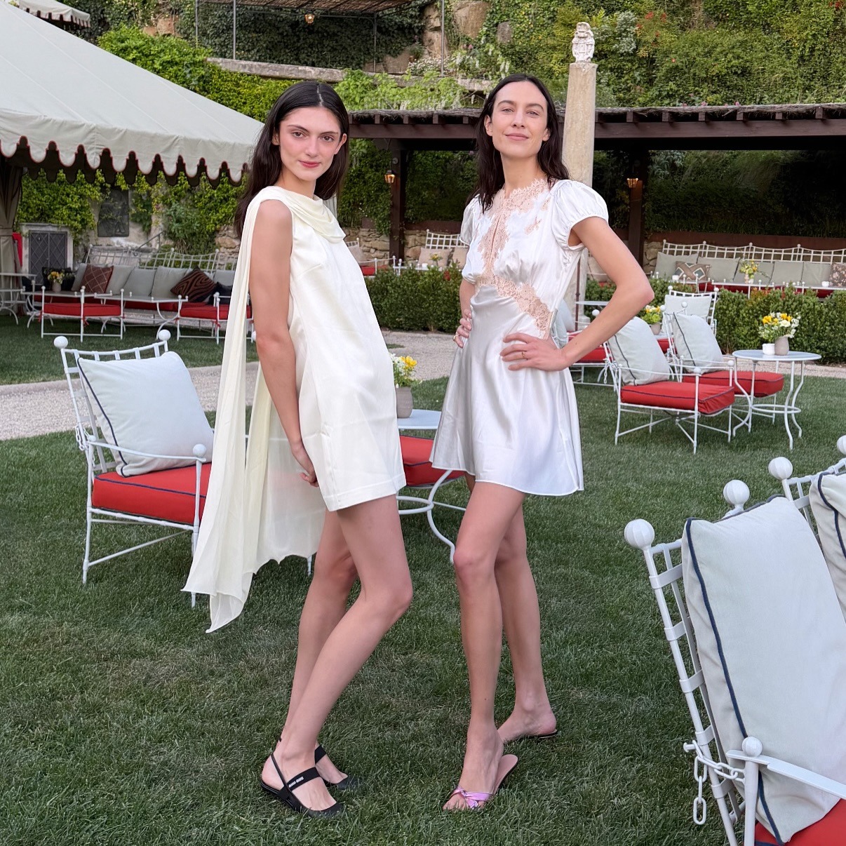 @alexachung poses for a photo in a satin lace-trim minidress and light pink mules.