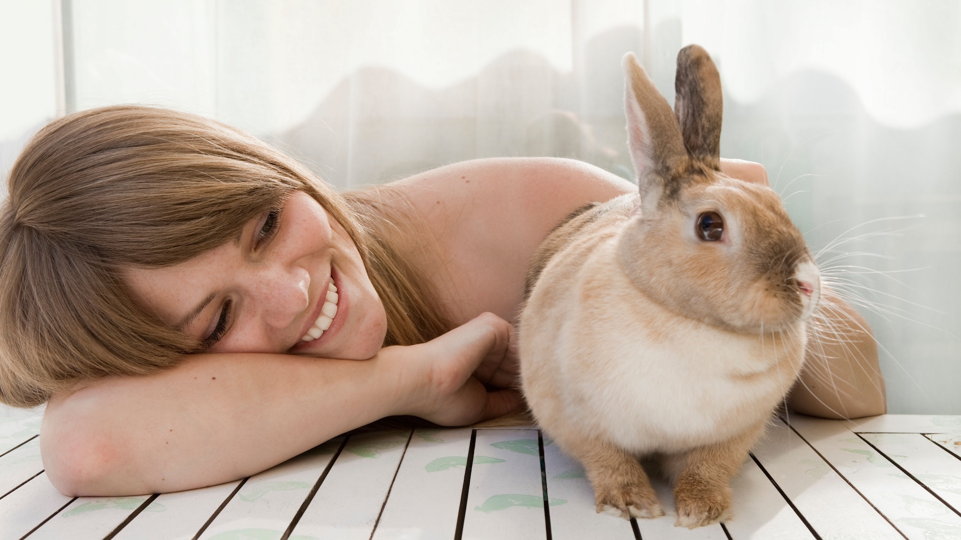 woman with pet rabbit on patio