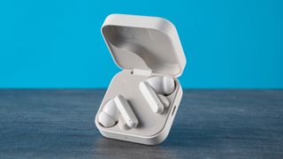 CMF Buds 2 Plus in light gray photographed in front of a blue background