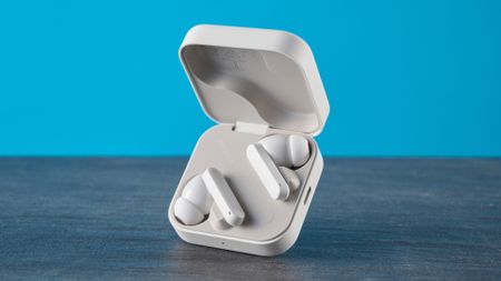 CMF Buds 2 Plus in light gray photographed in front of a blue background