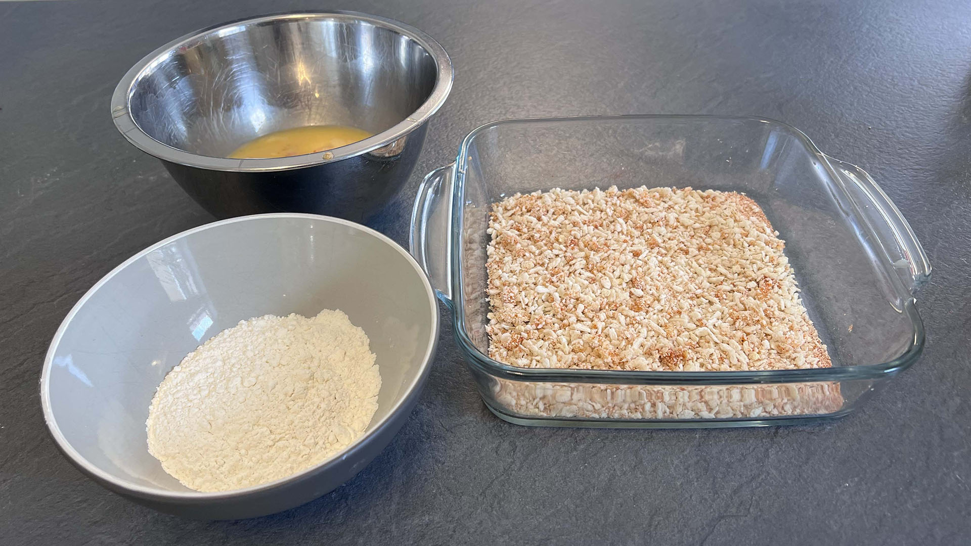 A bowl of egg, breadcrumbs and flour, ready for the shrimp to be dipped