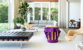 Living room with grey L-shaped sofa, black leather chaise lounge, and purple and gold sculpture