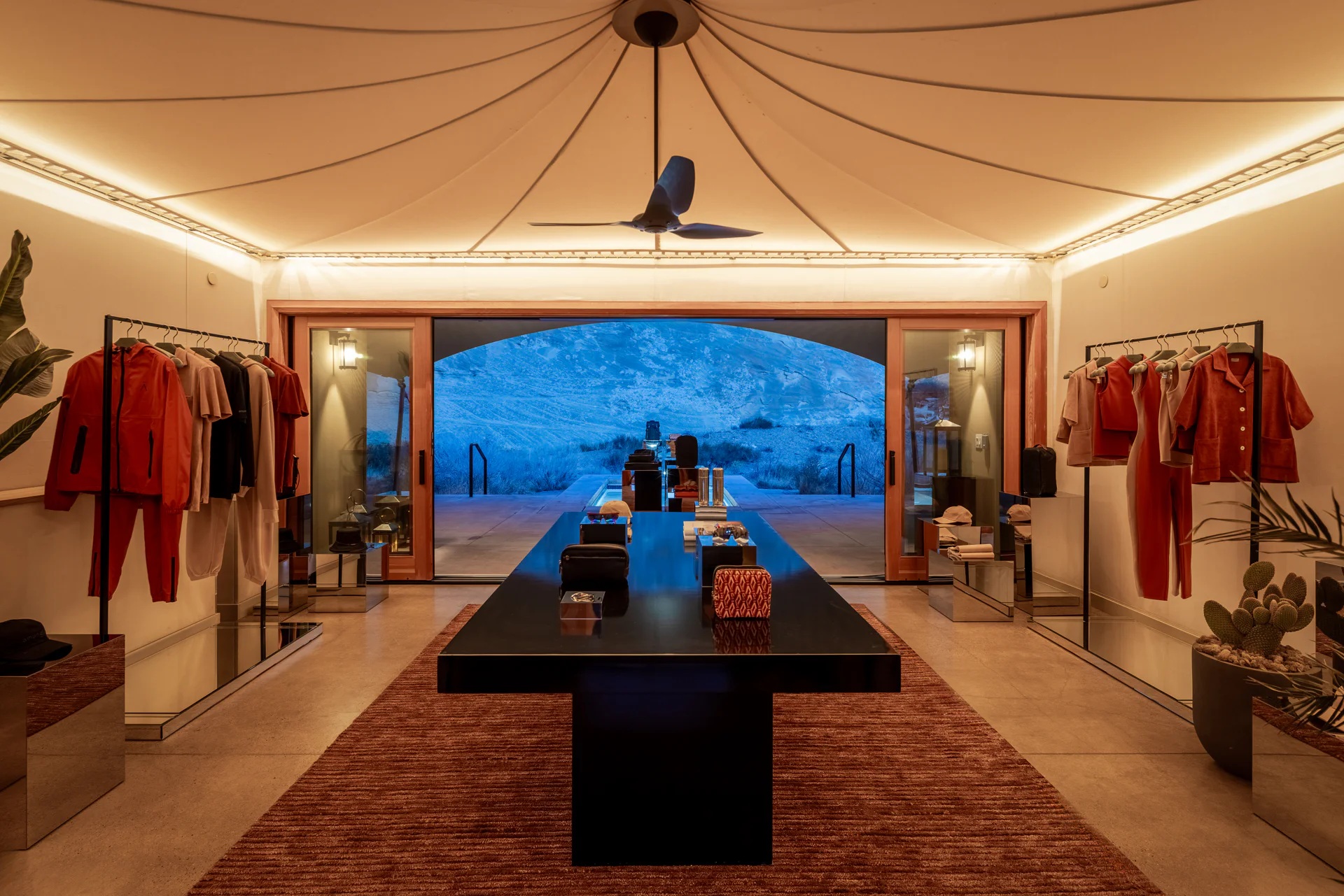The offering of a sleek hotel gift shop is set up among the dramatic mountain range of Utah's desert, nestled either within a camel tent decorated with sophisticated, reflective furniture, or en-plain-air in dialogue with the outdoors.