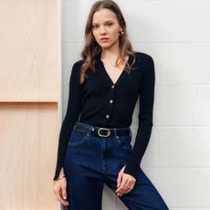 Model wearing jeans belt and black cardigan sold at Finery
