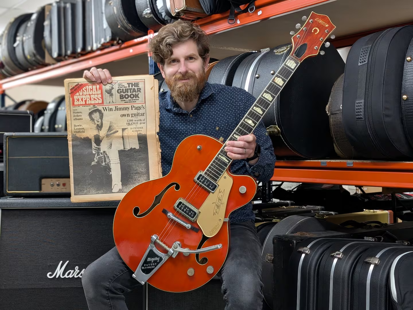 Gardiner Houlgate auctioneer Luke Hobbs holds the Grestch Chet Atkins 6120 guitar once owned by Jimmy Page guitar and a copy of the NME magazine announcing the guitar would be given away in a contest. The guitar goes on the auction block at Gardiner Houlgate on September 9, 2025