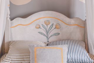 A bedroom with a painted headboard