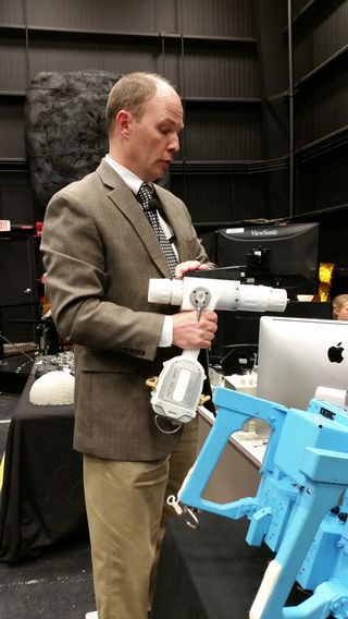 Ben Reed, of NASA's Satellite Servicing Office, holds the Pistol Grip Tool used by astronauts servicing the Hubble Space Telescope.