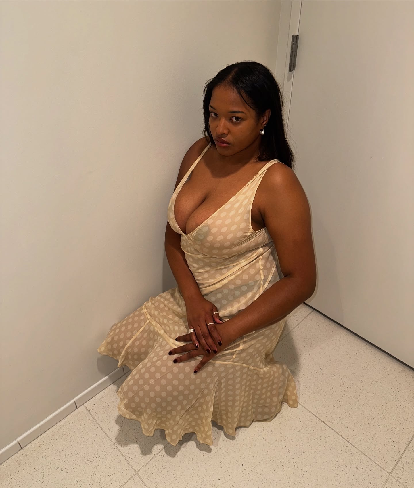An image of @_imanirandolph wearing a sheer polka-dot dress.