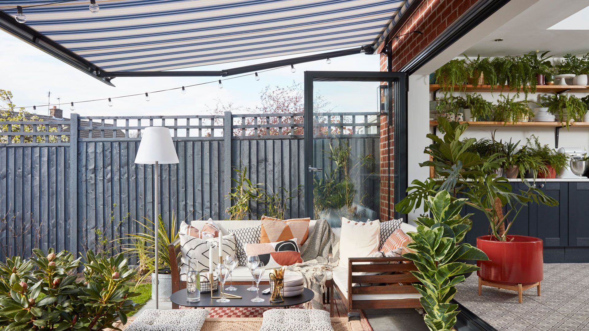 Outdoor living room iea on patio with retractable motorised awning for shelter and shade