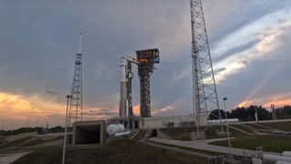 a large white rocket on a launchpad at sunset