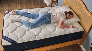 Sleep staff writer Ruth Jones lies on her stomach on the DreamCloud Luxury Hybrid mattress