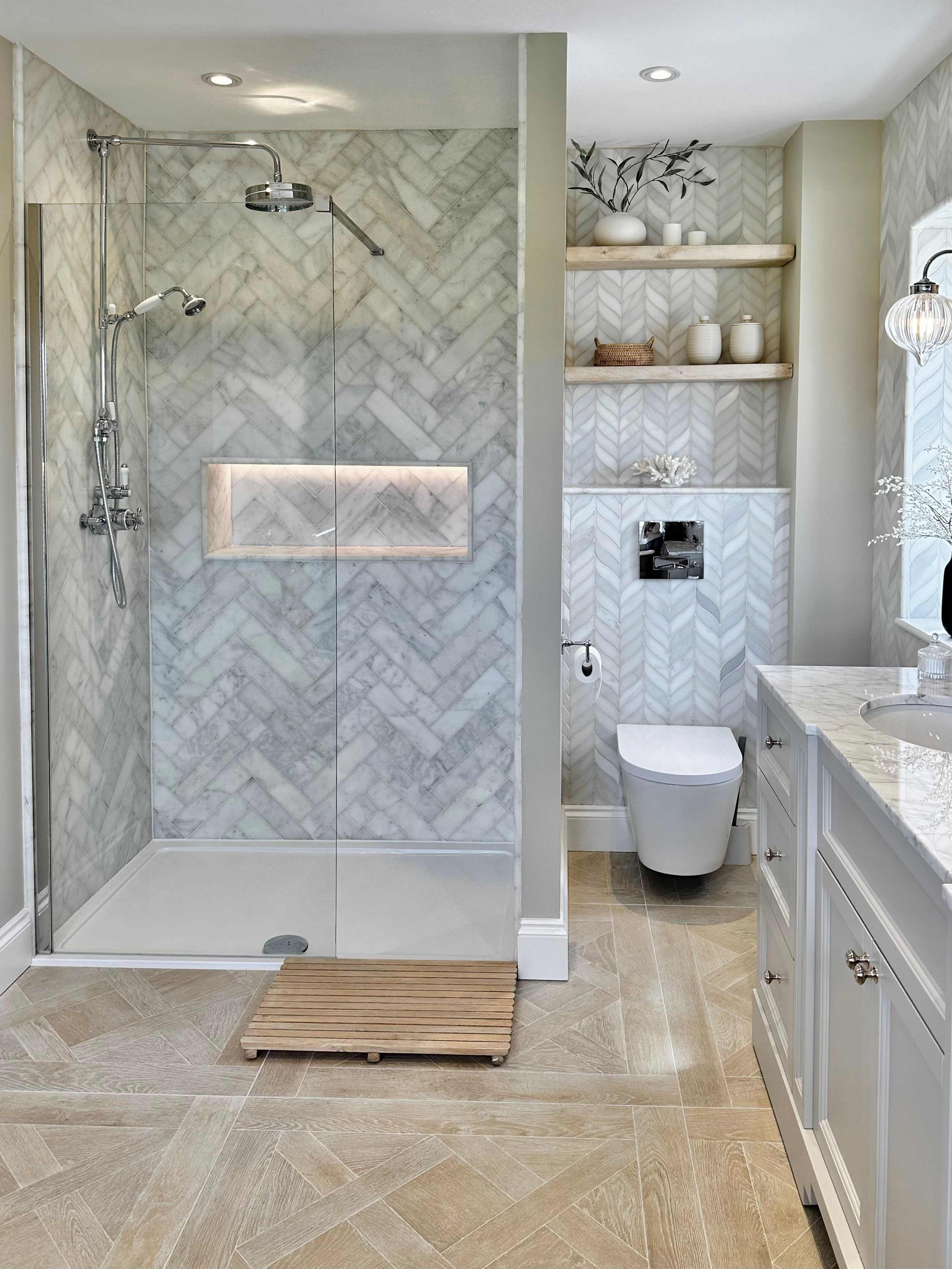 A shower room with a shower as well as a toilet and open shelving above the toilet