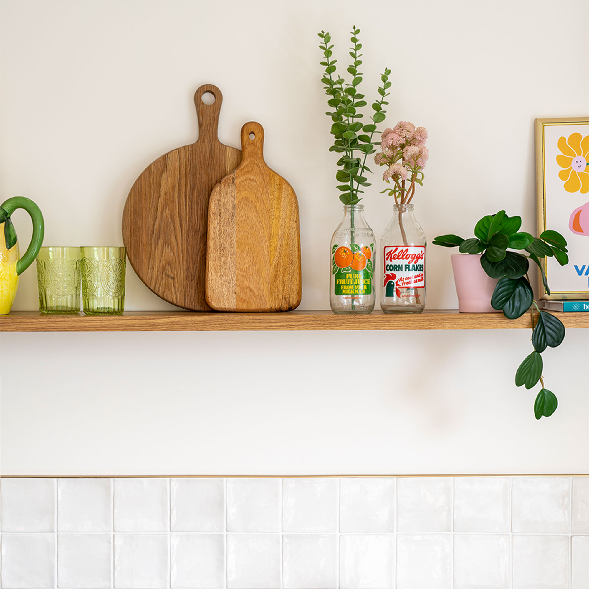 Green kitchen with white tiles and wooden shelf