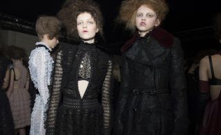 Models wearing black dress and black coat