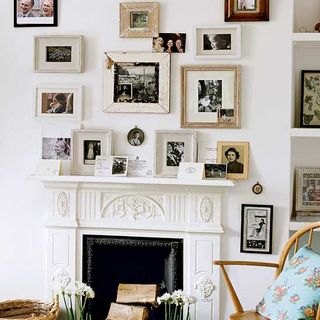 Many framed pictures and photos decorating white mantelpiece