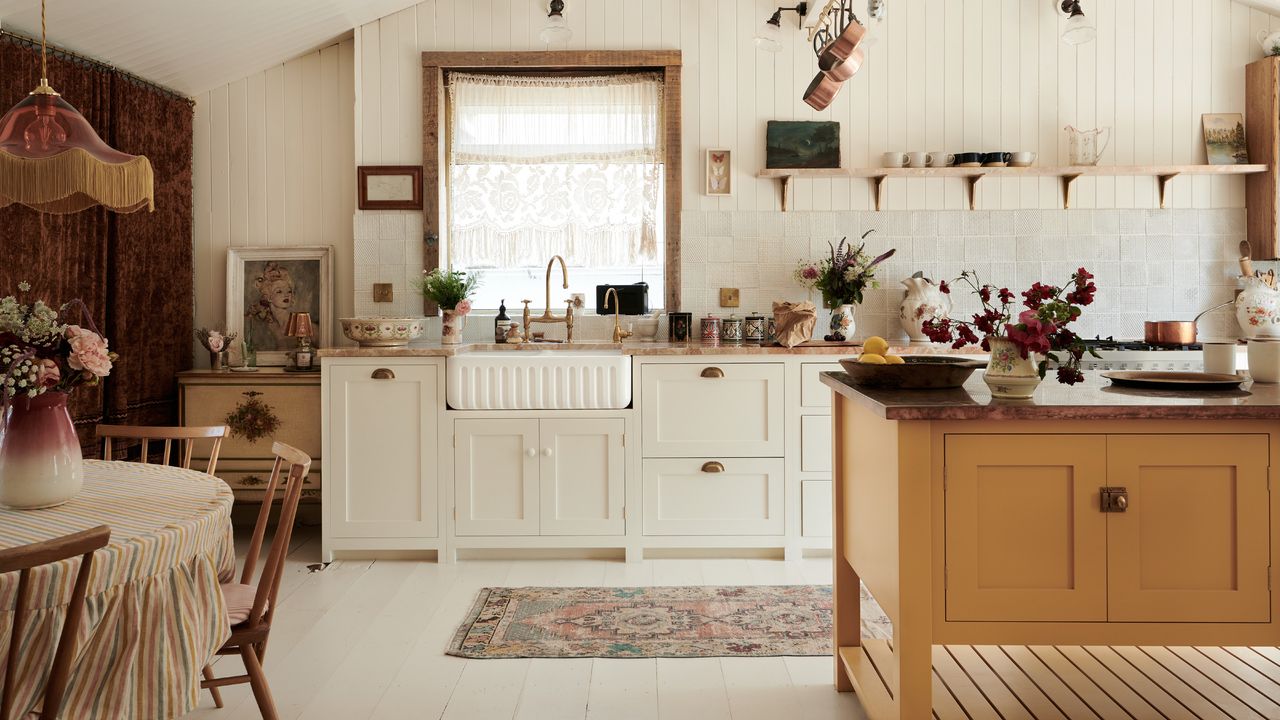 design a home that feels like you, vintage style kitchen with shiplap walls and ceiling, open shelving, fluted sink, mustard kitchen island, lace at window, brass faucet, artwork, fringed pendant light, dining table 