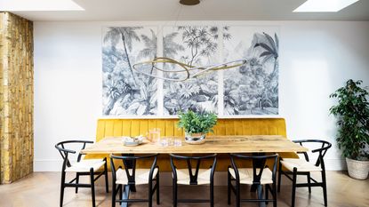 Dining room with wooden parquet flooring, ochre bench and three panelled mural