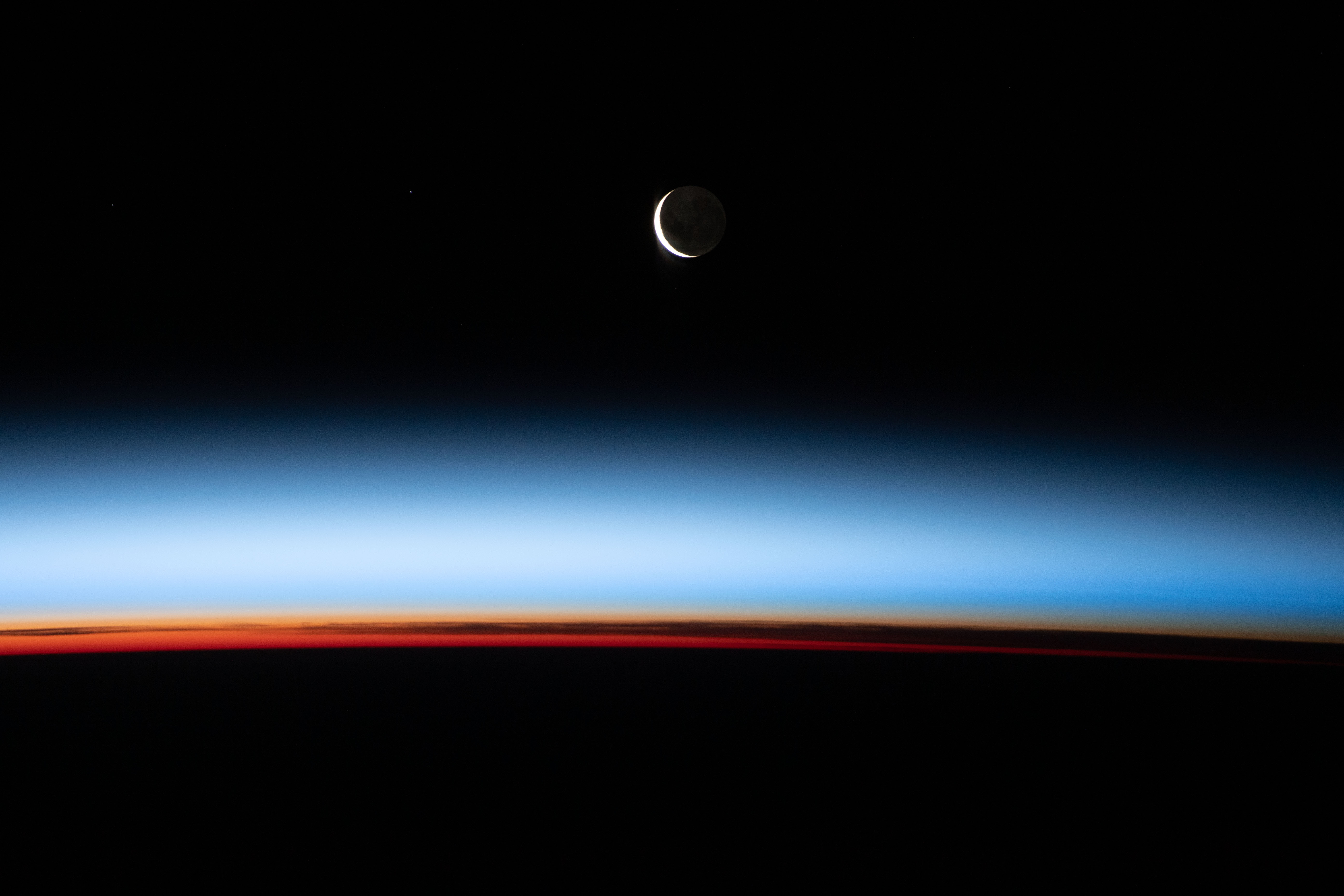 A waxing crescent moon is photographed from the International Space Station during an orbital sunset as the station flies 268 miles (431 kilometers) above the Pacific Ocean, east of New Zealand.