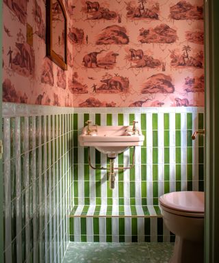 Vibrant bathroom with coral wallpaper, green vertical tiles, pink basin