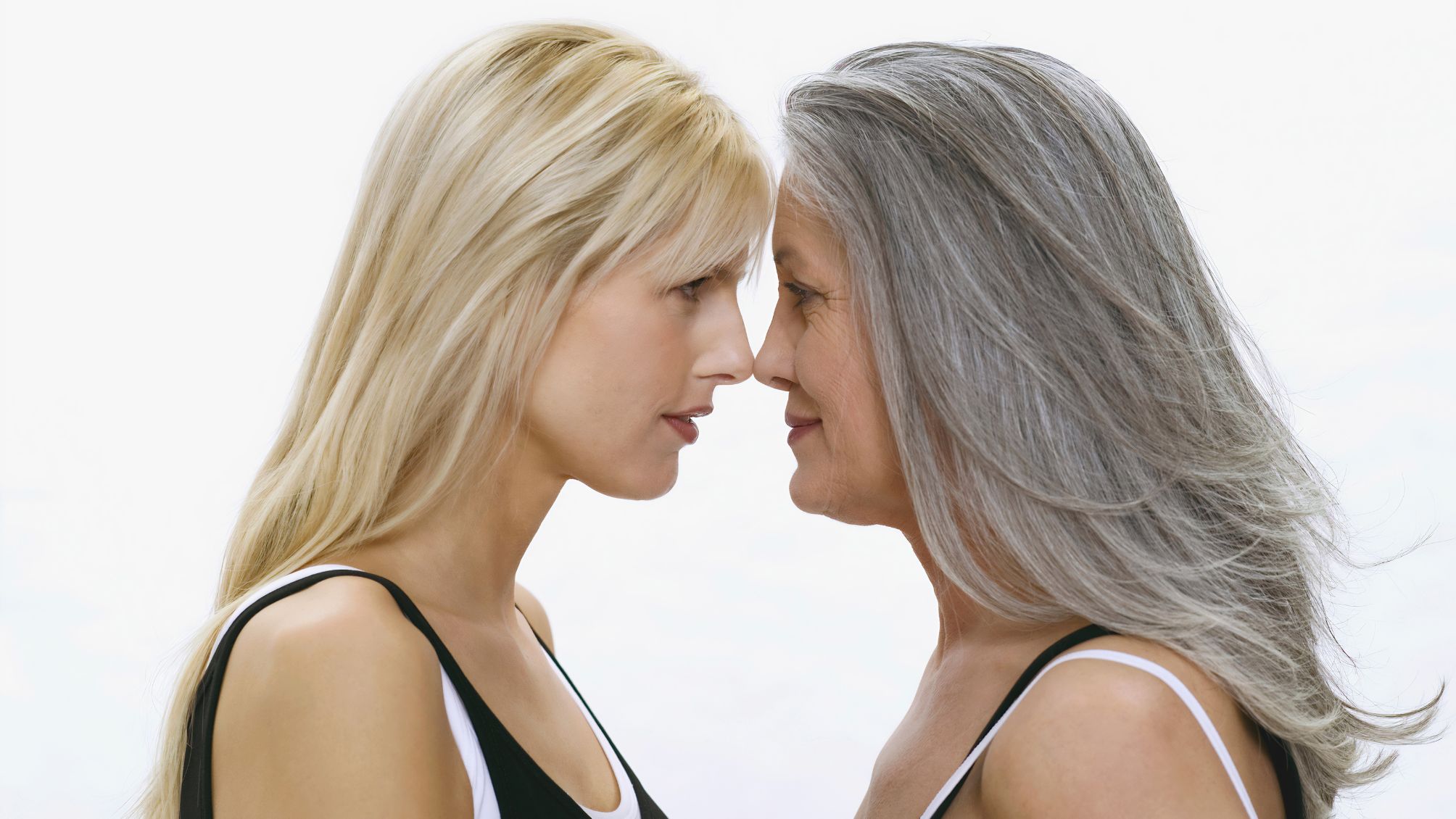 A mother and daughter nose to nose on a white background