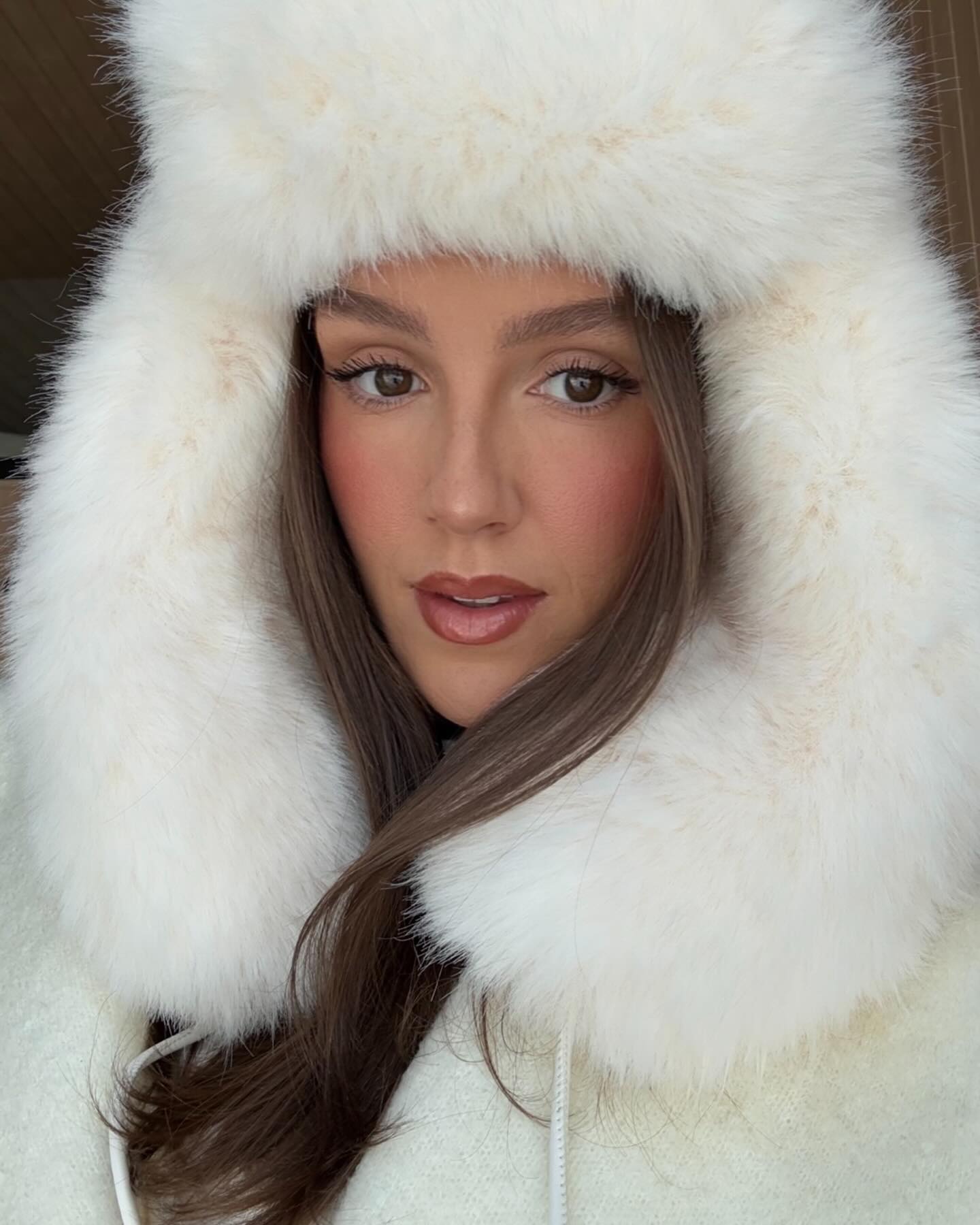 Emm Leger with a glowing complexion, flushed cheeks, and matte, mauve lips