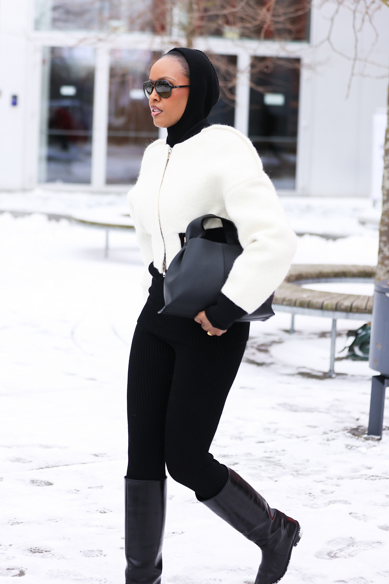 woman wearing all black and a white jacket in Copenhagen