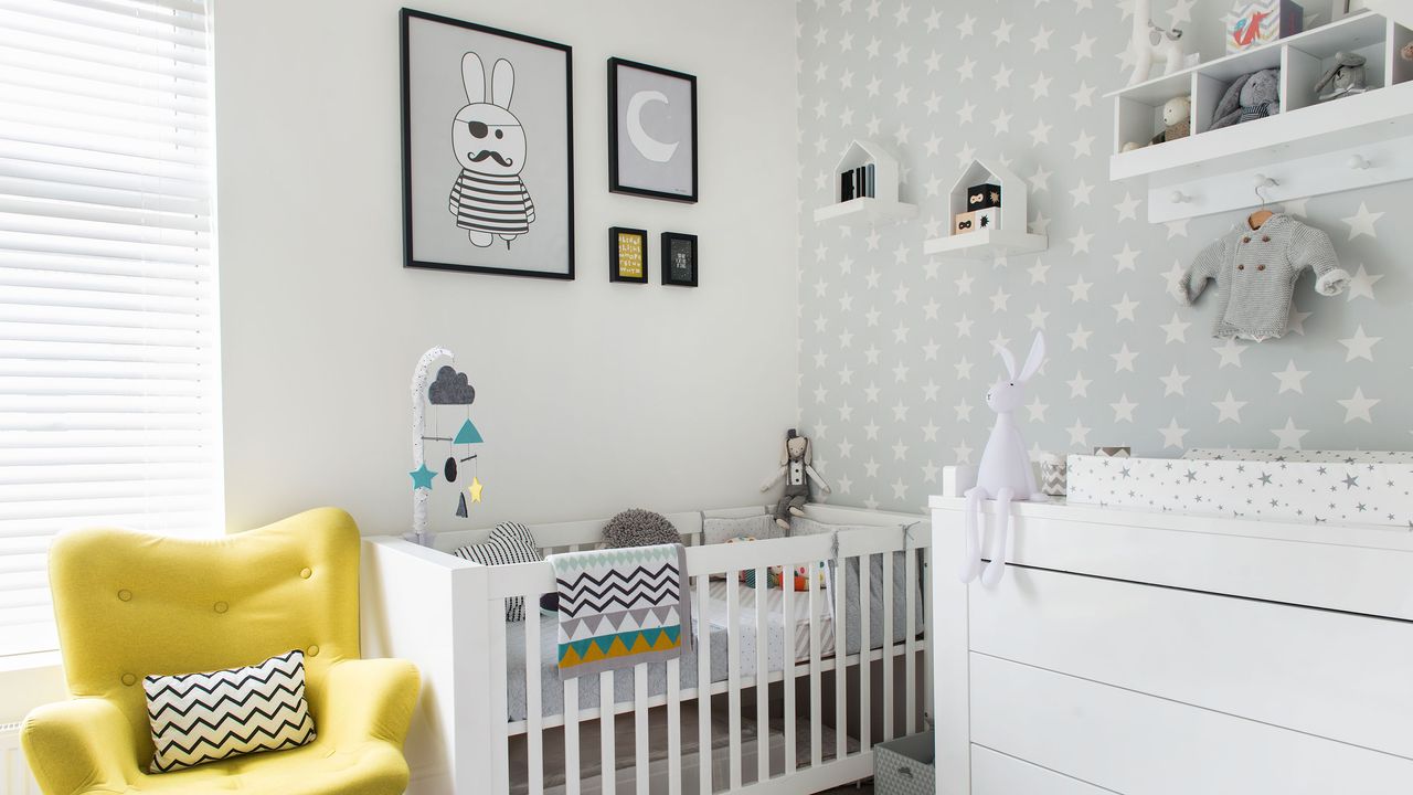 White nursery with crib, graphic artwork and yellow chair