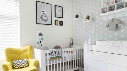 Grey boucle armchair with wooden legs, with white blanket and cushion beneath wooden shelves