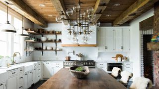 Large farmhouse kitchen with rustic wooden shelves and glass globes chandelier