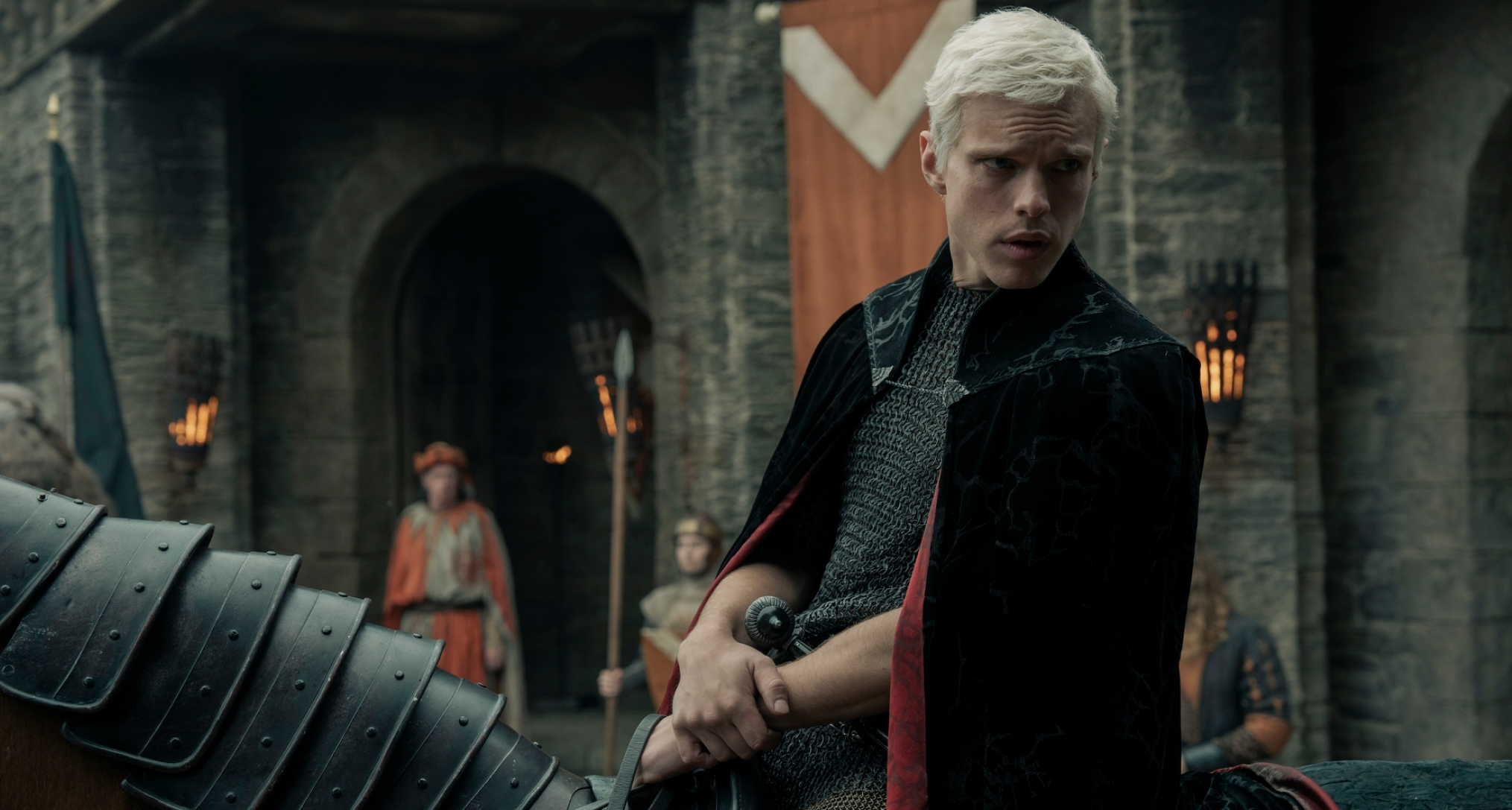 finn bennett as prince aerion targaryen riding on horseback through a medieval town in a still from a knight of seven kingdoms