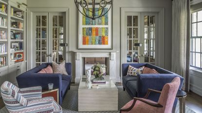 Living room with colorful artwork and blue couches