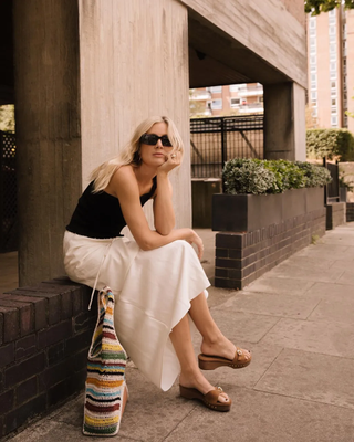 @lucywilliams02 wearing a white skirt and tank top