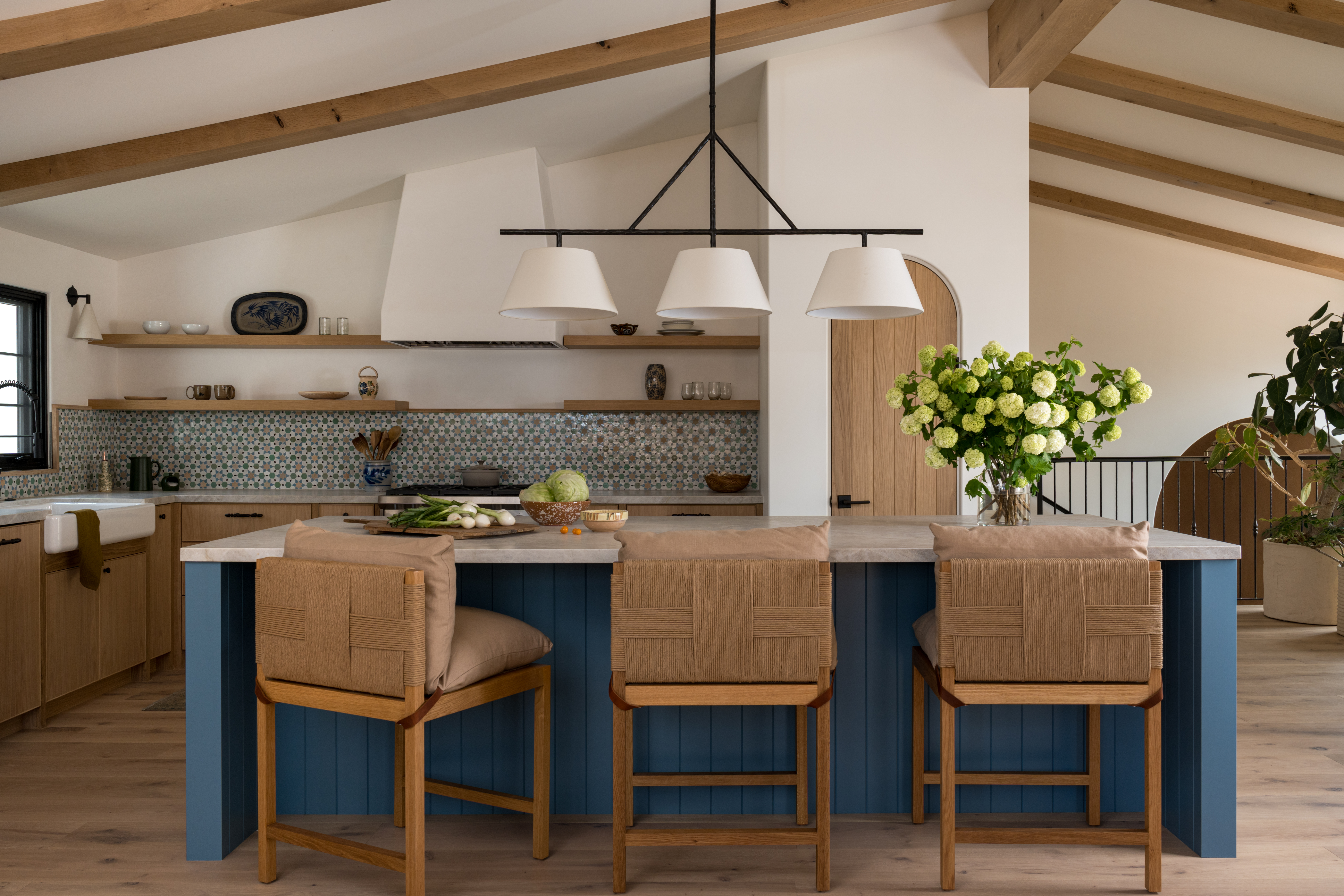 Kitchen with large blue island and stools