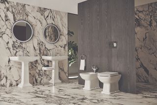 A large modern bathroom with marble walls and floor and two sinks