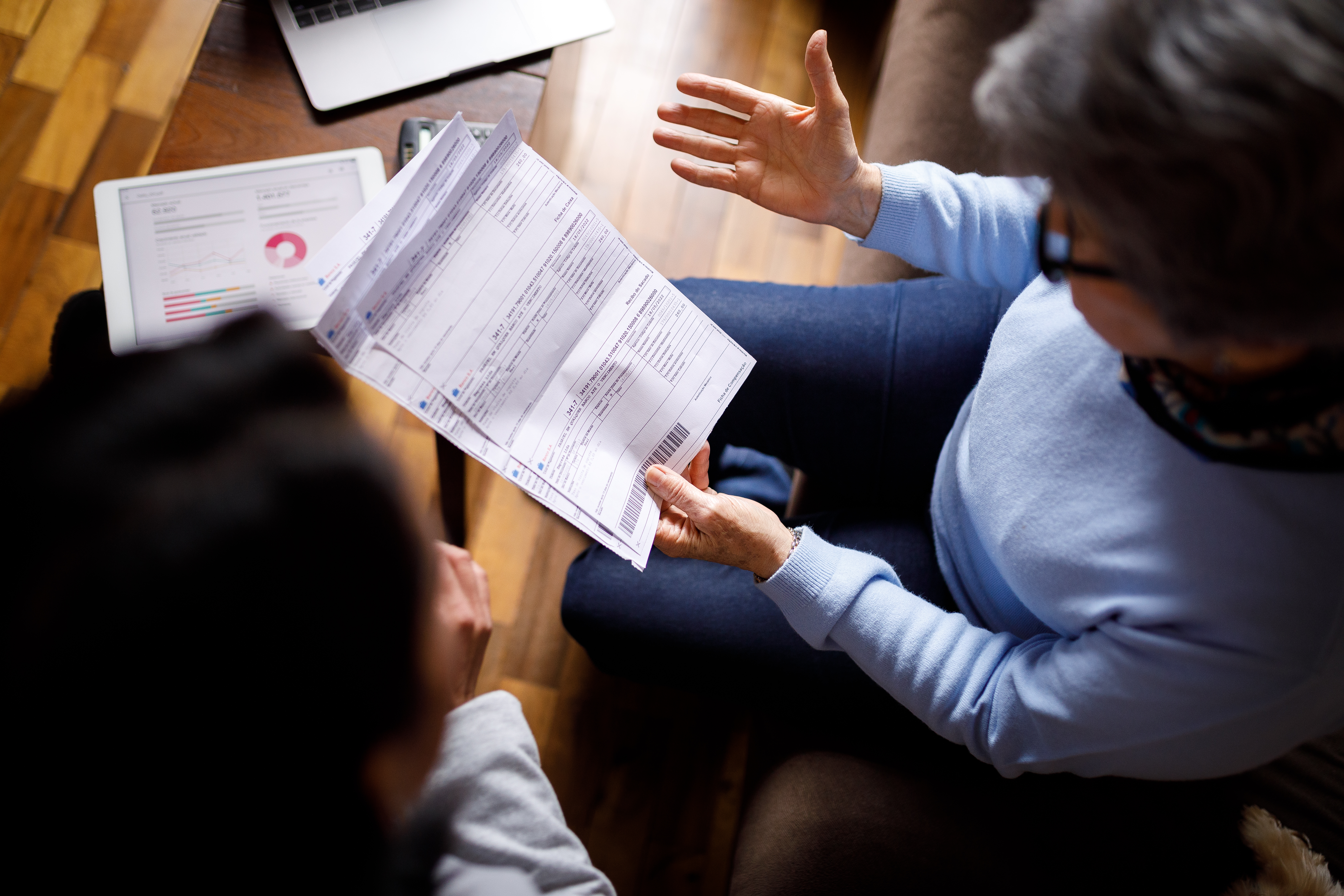 Family looks worried as they look at tax bill on paper in bird's eye view shot.