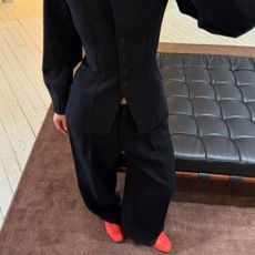 @mimixn wears red mesh flats with black trousers and a black blazer