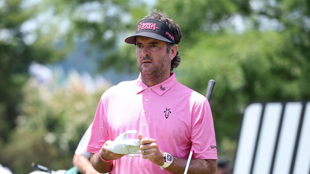 Bubba Watson - wearing his classic pink polo and a black RangeGoats cap - looks on during LIV Golf Nashville in 2024