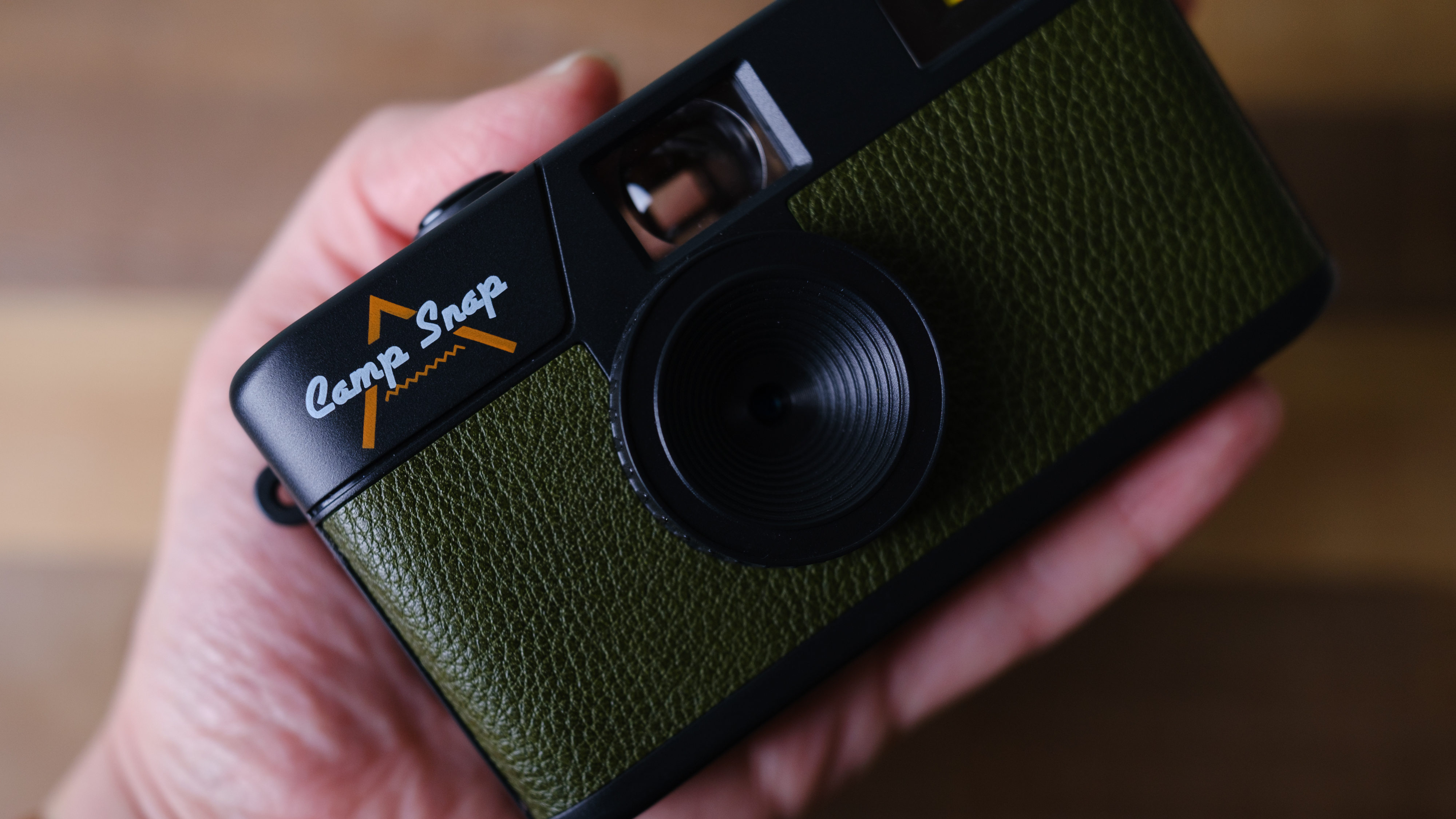 The Camp Snap camera, in forest green, sits on a table