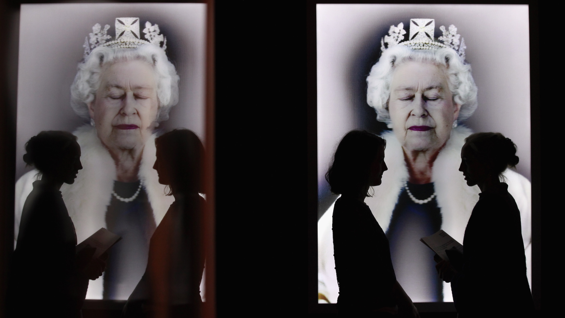 Members of the public view an image of Her Majesty Queen Elizabeth II by artist Chris Levine entitled 'Lightness of Being' in the National Portrait Gallery's exhibition 'The Queen: Art &amp;amp; Image'