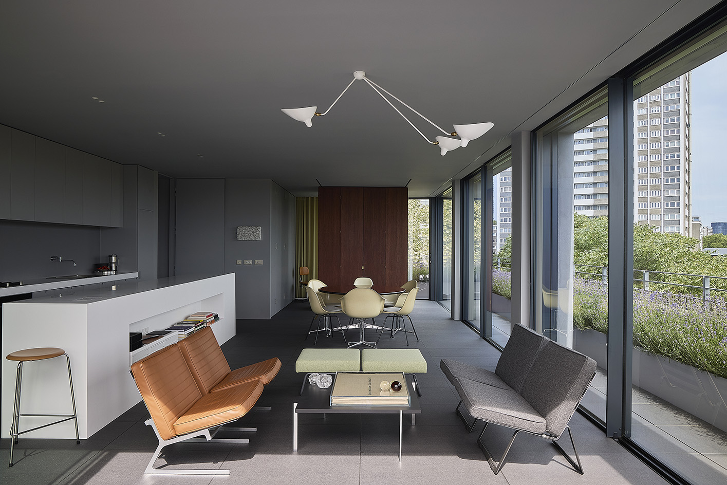 Clerkenwell Rooftop apartment in London, showing minimalist concrete and large openings with terrace and views out to urban views with green