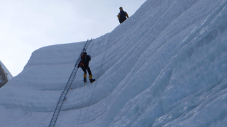 Vivian James Rigney scaling a ladder on Everest