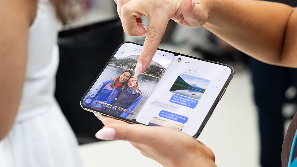 A woman pointing at the iPhone Duo's unfolded display