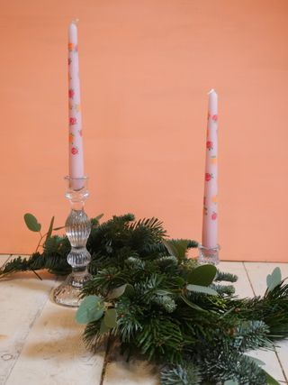 Two candles and festive garland on a table