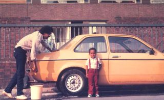 Jonathan Hagos as a child in front of his parents orange car