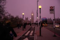 Commuters cross Westminster Bridge near the Houses of Parliament