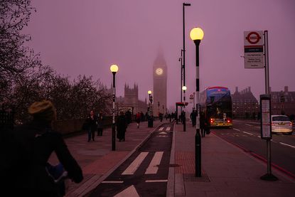Commuters cross Westminster Bridge near the Houses of Parliament