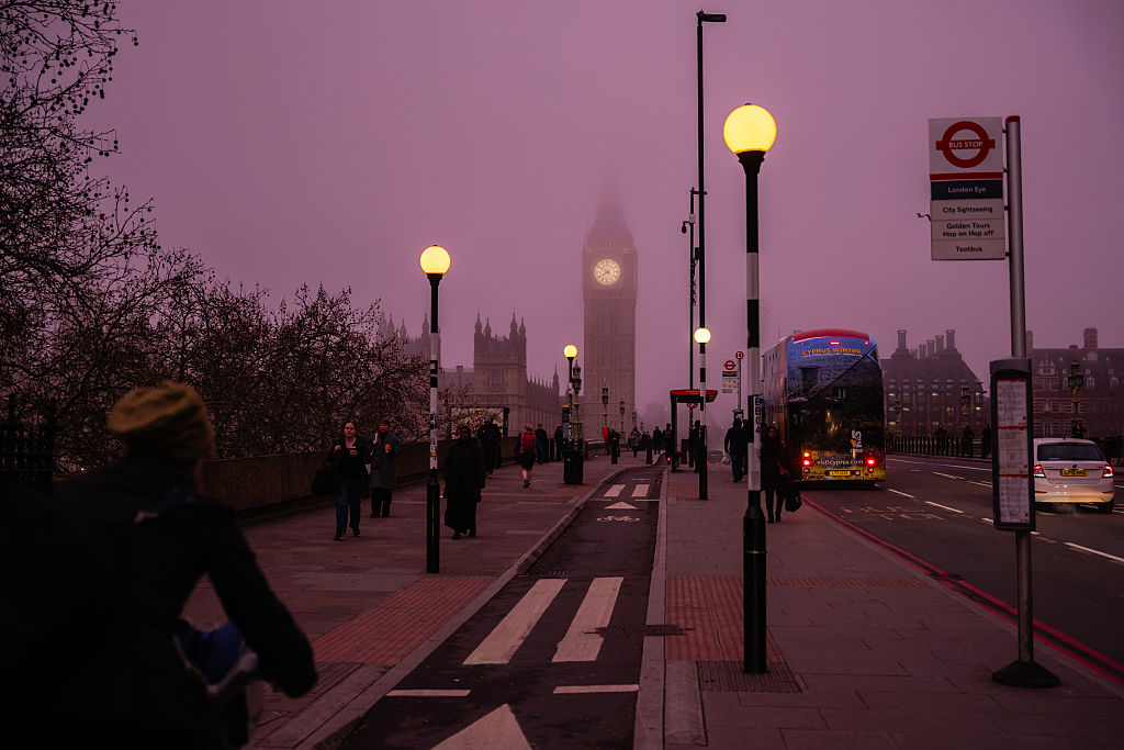 Commuters cross Westminster Bridge near the Houses of Parliament