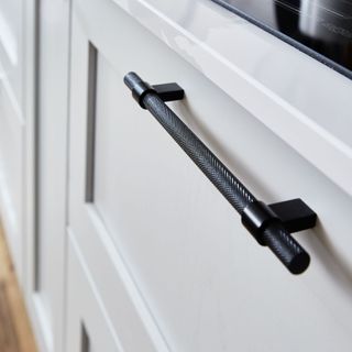 Howdens Chilcomb dove-grey shaker cupboard door with knurled black handle.