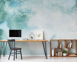 Organized hairpin desk in front of abstract mural feature wall.