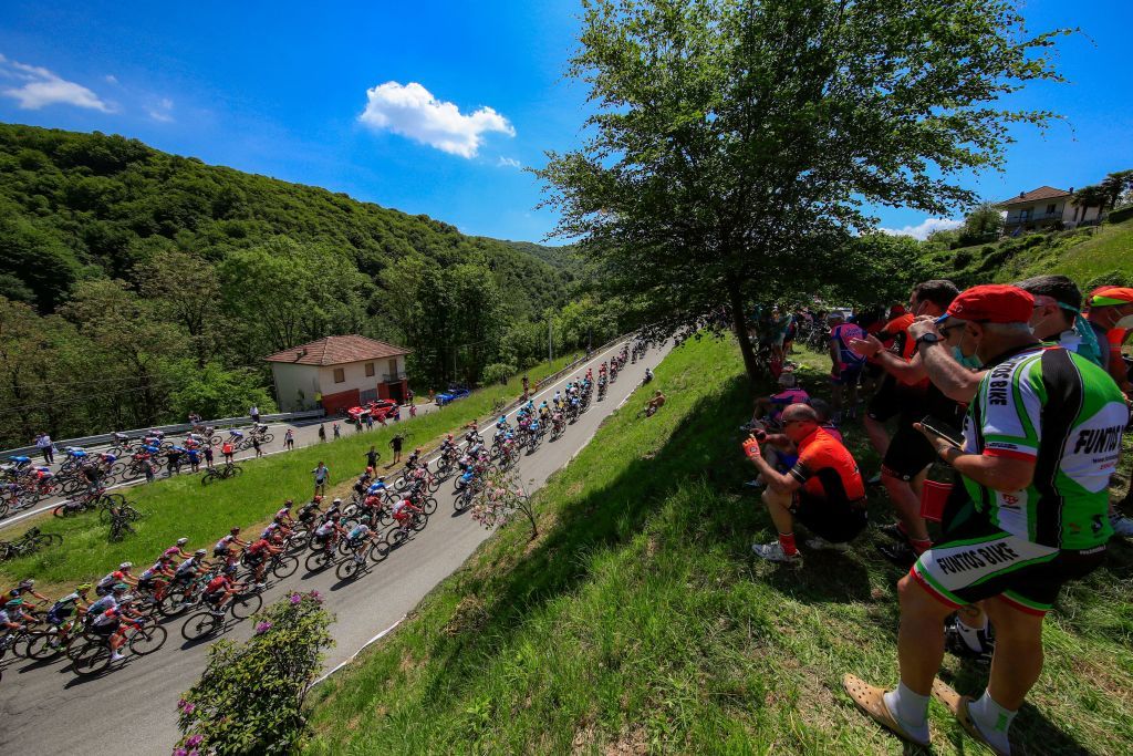 Spectators watch riders of the pack in Sovazza during the 19th stage of the Giro dItalia 2021 cycling race 166km between Abbiategrasso and Alpe di Mera on May 28 2021 Photo by Luca Bettini AFP Photo by LUCA BETTINIAFP via Getty Images